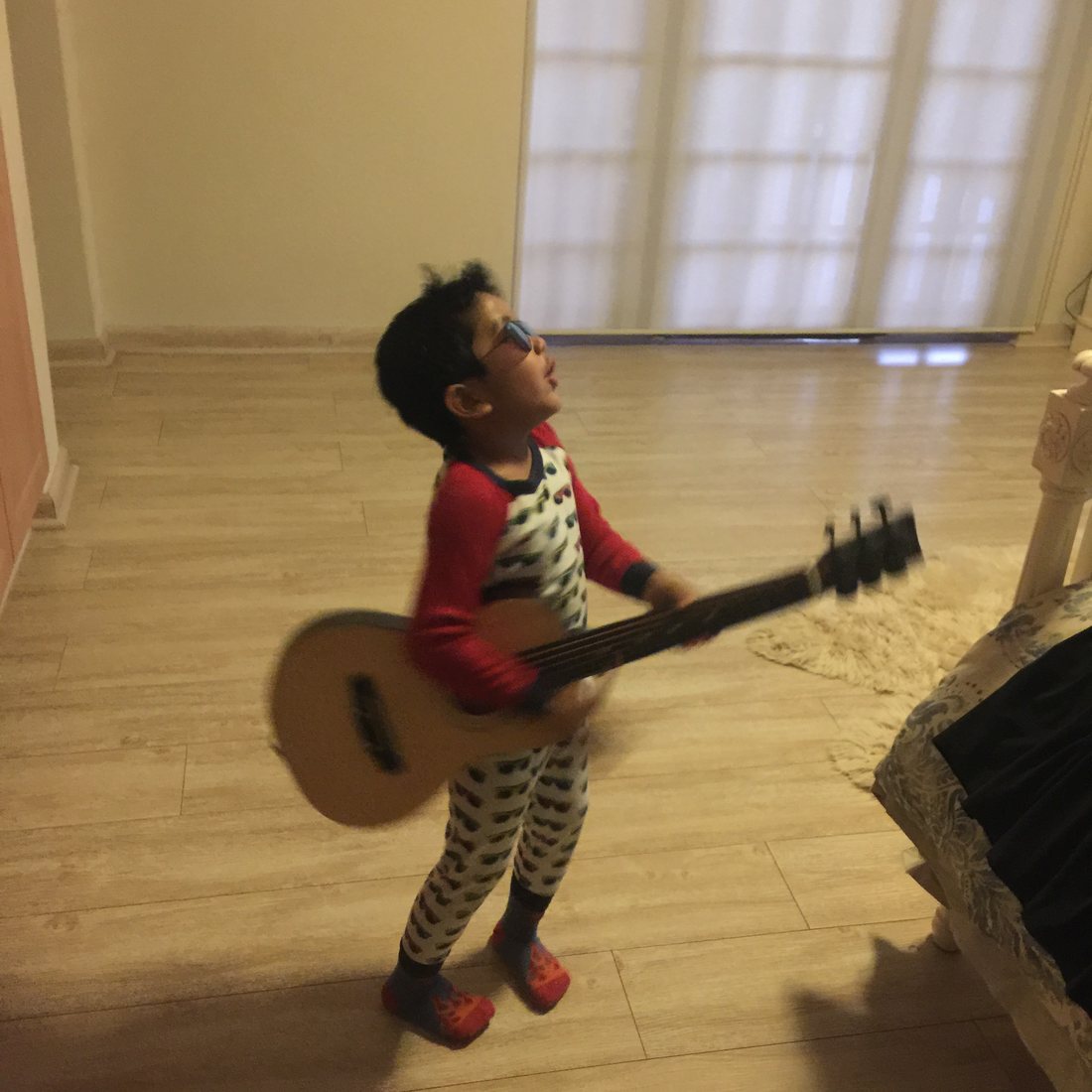 Hridhaan as a child holding a guitar indoors