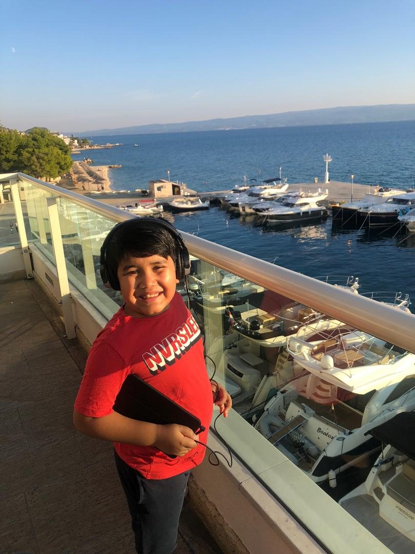 Hridhaan as a child smiling beside a waterfront